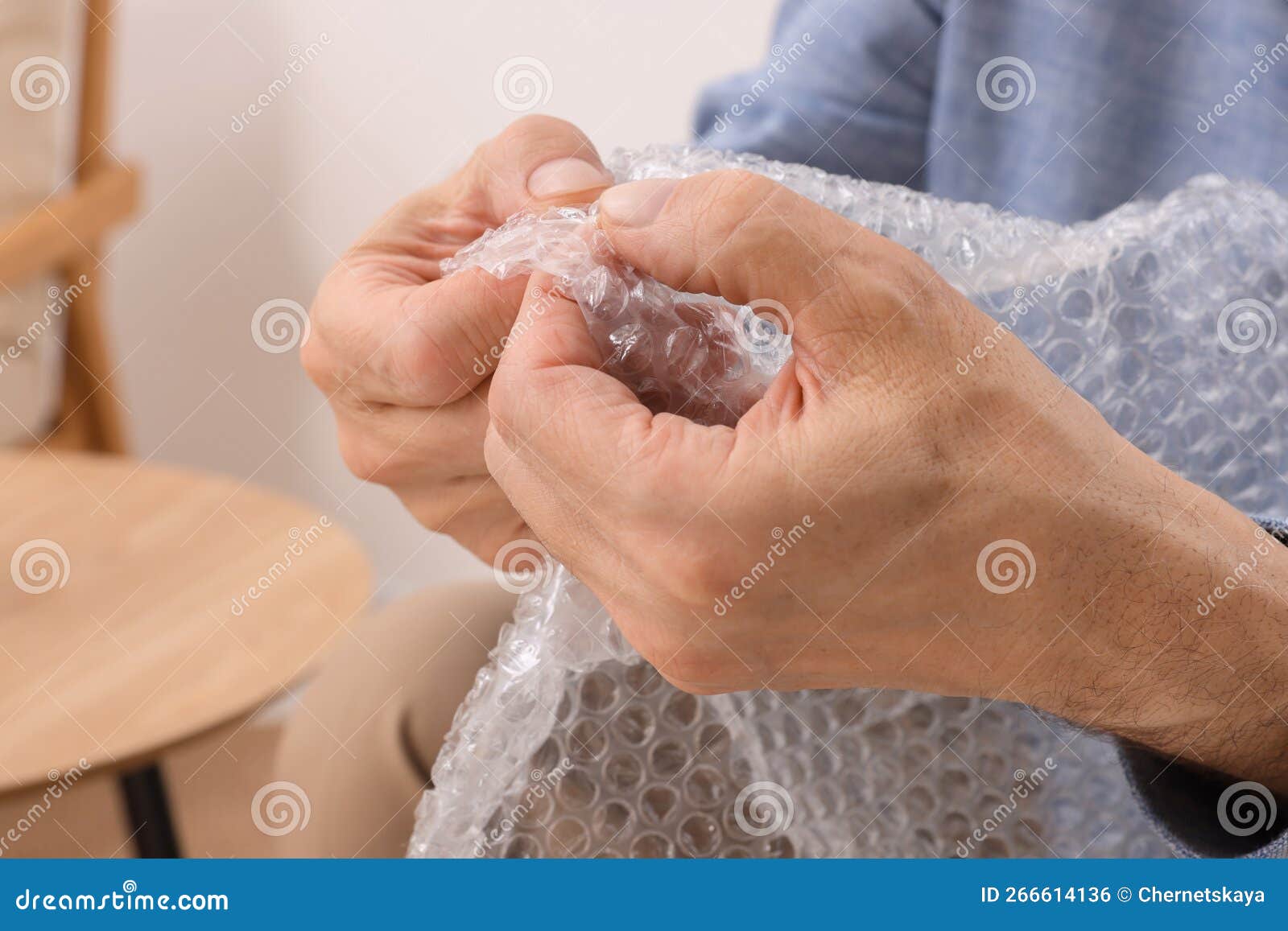 Senior Man Popping Bubble Wrap at Home, Closeup. Stress Relief Stock