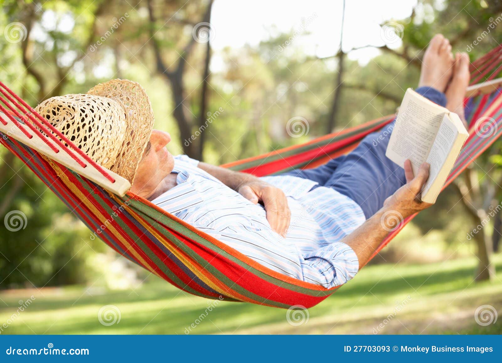 senior man relaxing in hammock with book