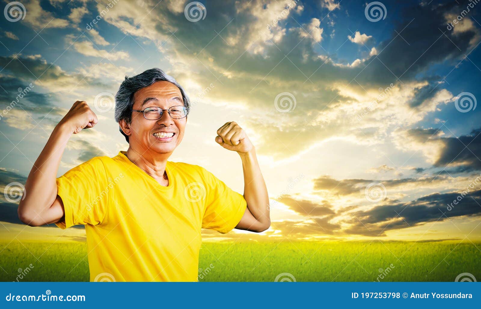 senior man showing off muscle for strong healthy lifestye concept with golden nature sky background