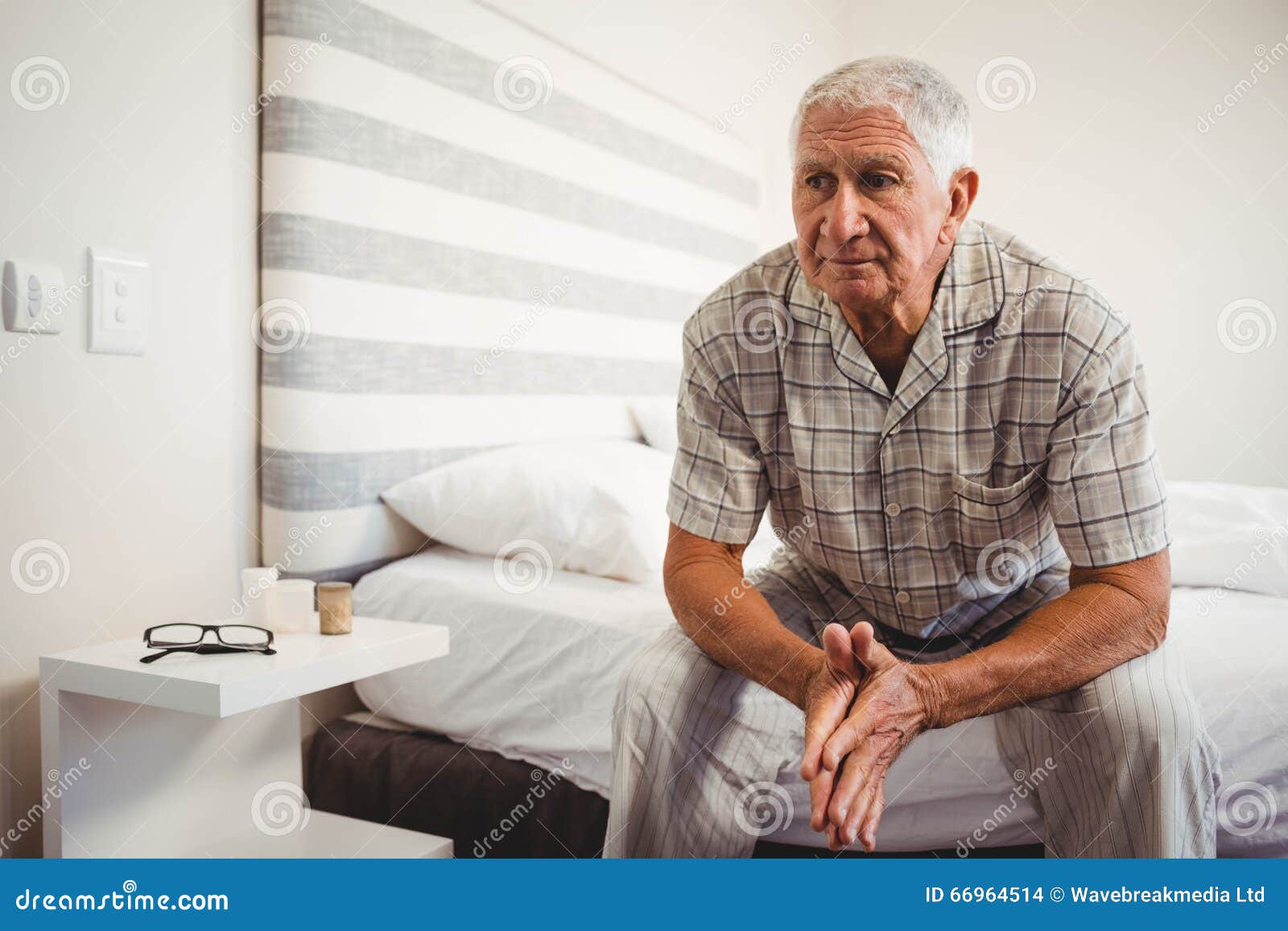 Senior man sitting on bed stock photo. Image of front 66964514