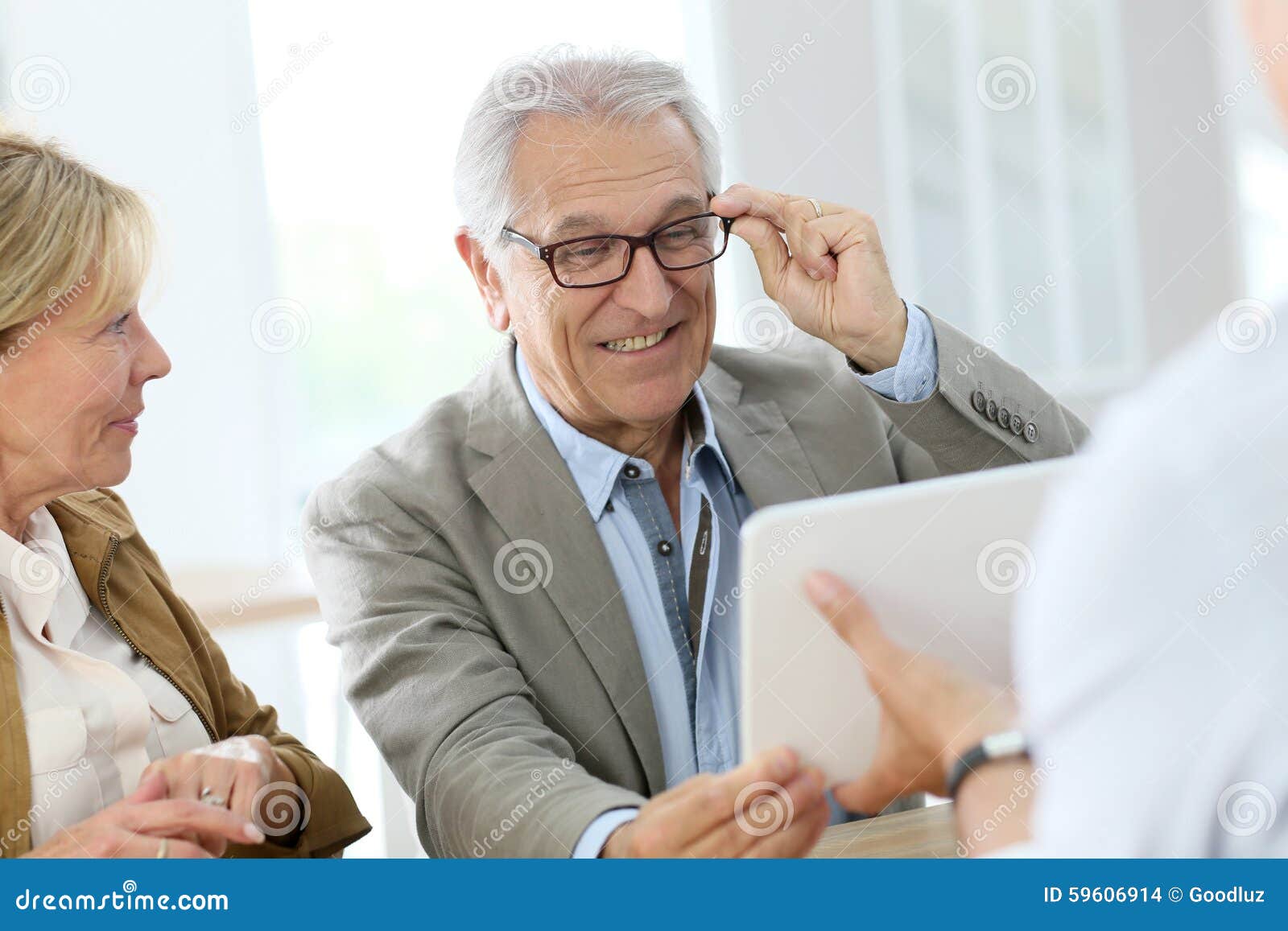 senior man trying on eyeglasses in optical store