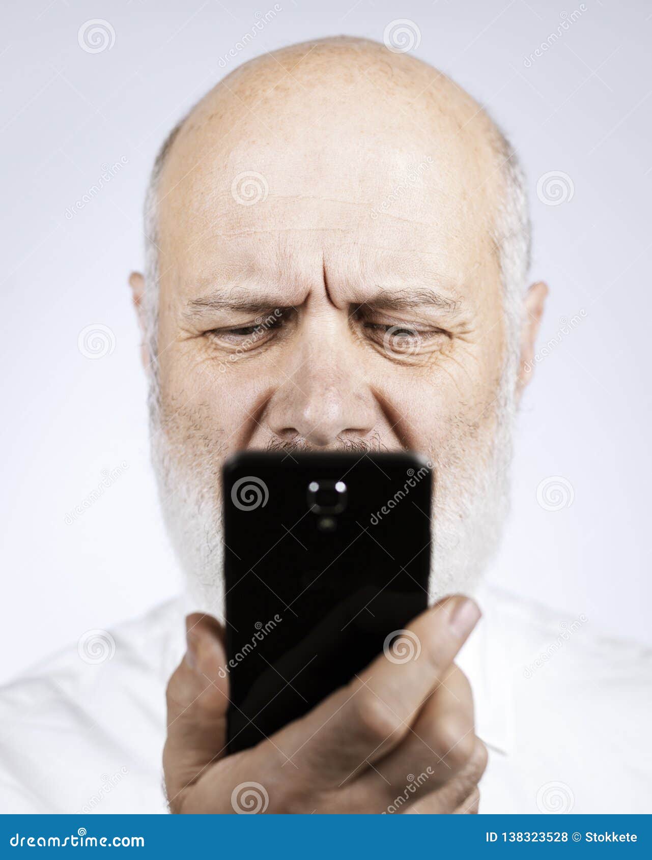 Senior Man Using a Phone and Having Eyesight Problems Stock Photo