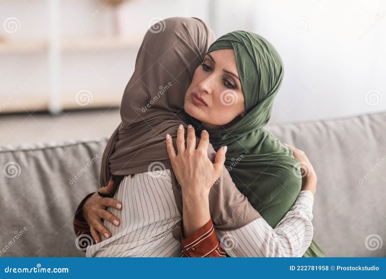 Senior Muslim Mother Hugging Unhappy Adult Daughter Wearing Hijab Indoor Stock Photo picture