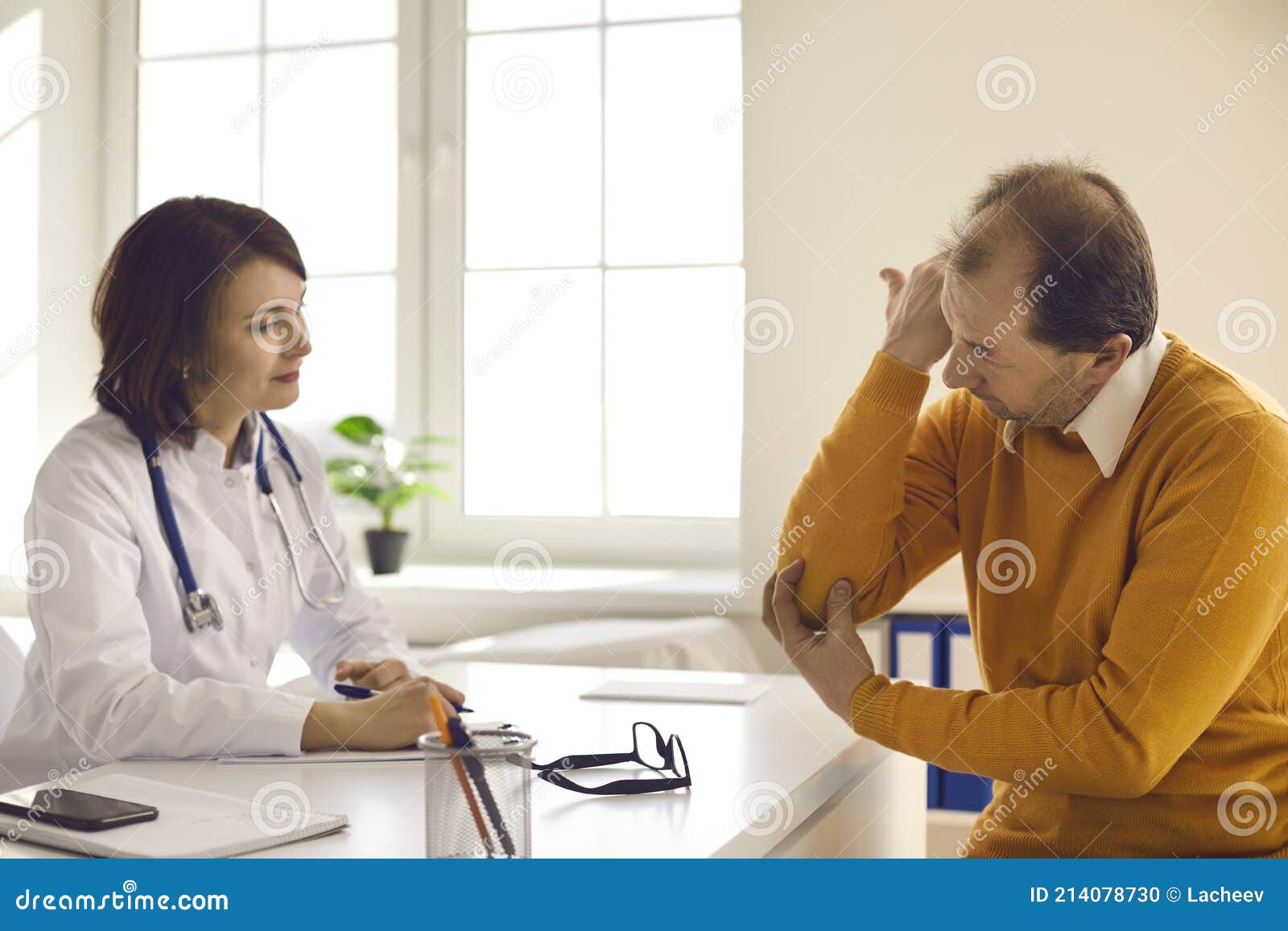 senior patient visiting clinic and telling general practitioner about his elbow pain