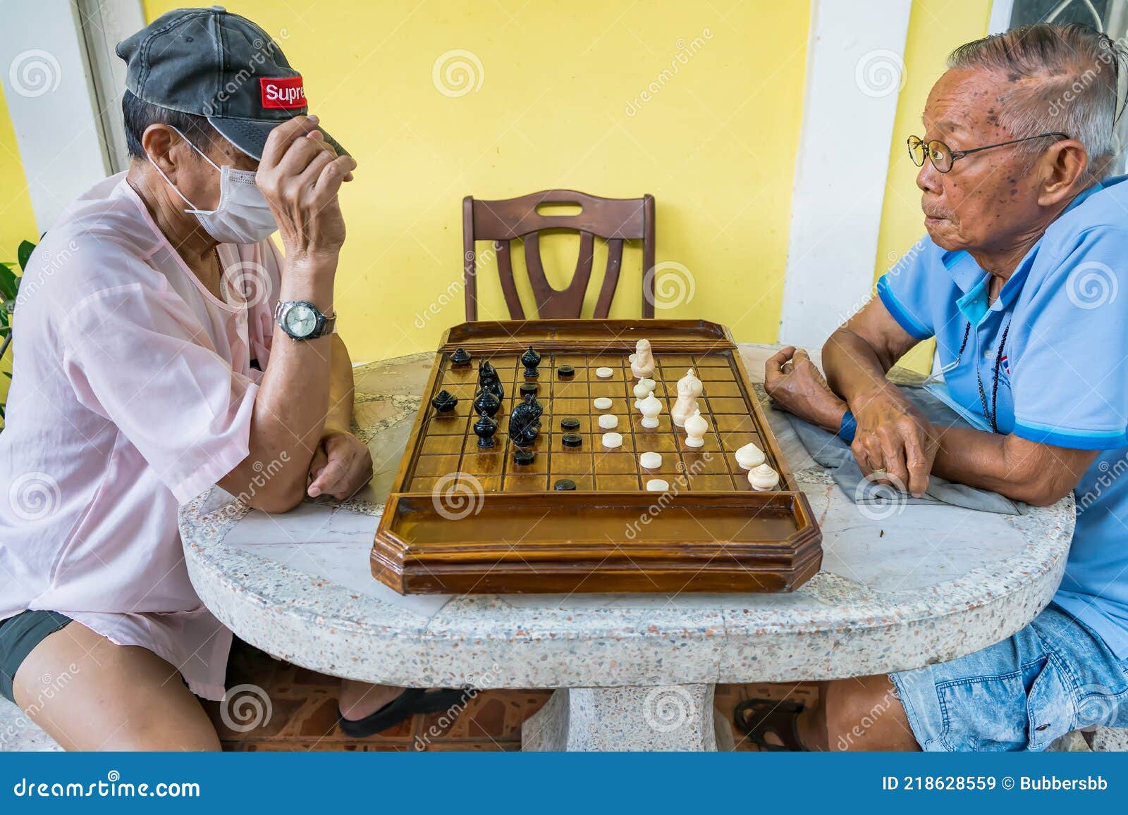 Local Thai people play old traditional Thai chess in public area - slow  life style local people with chess board game concept Stock Photo