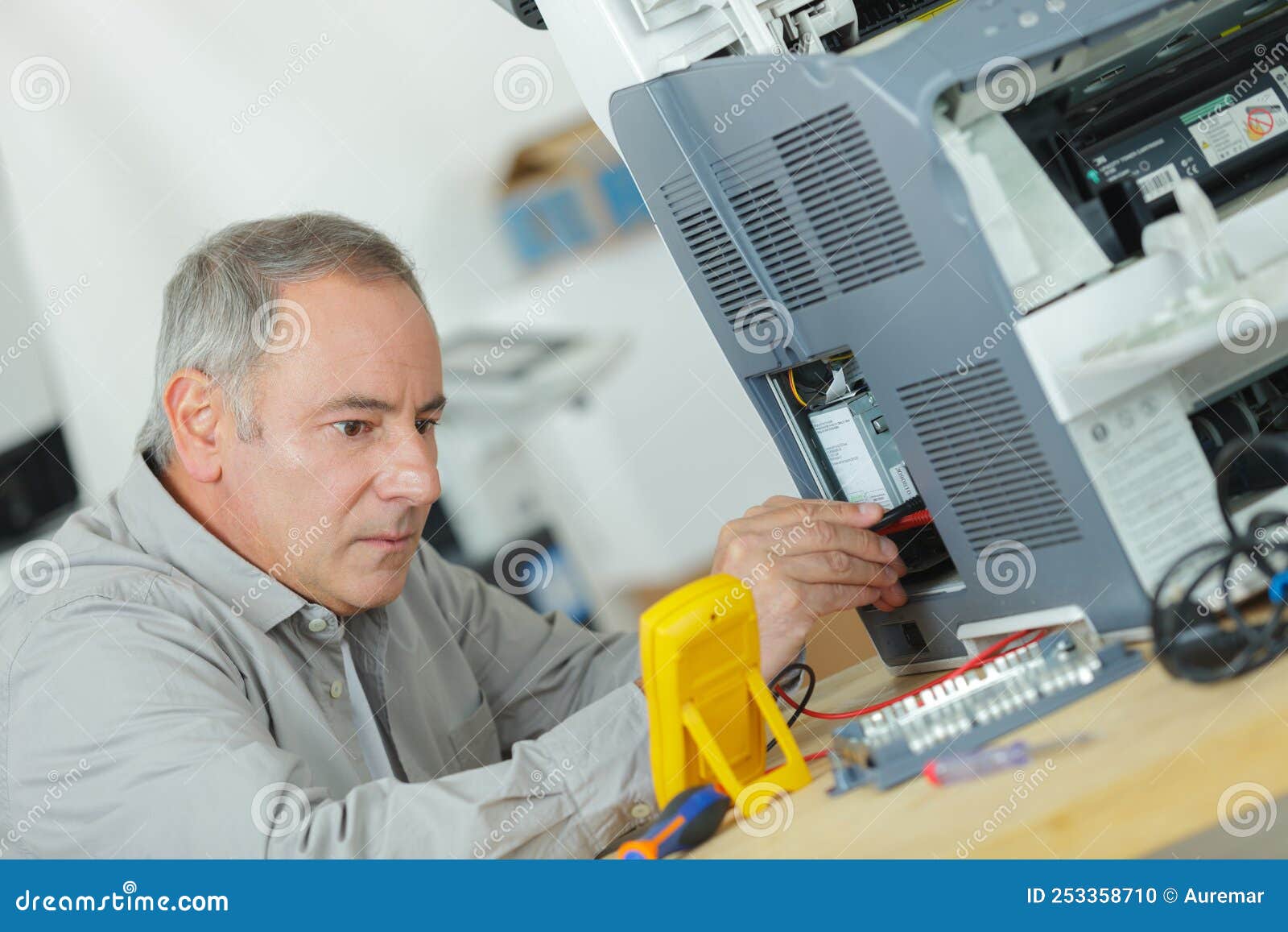 Senior Technician Using Multimeter To Test Electrical Appliance Stock