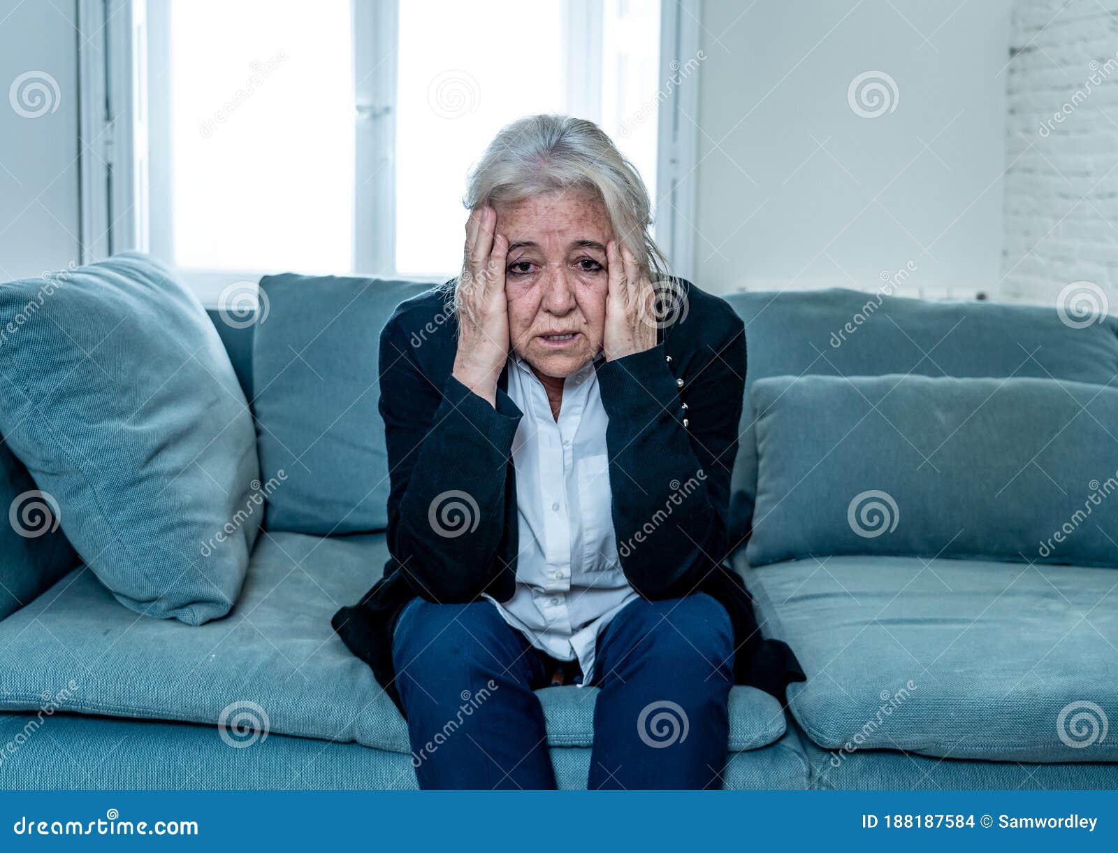 Senior widow woman lonely and sad feeling depressed at home. Lonely depressed senior old widow woman crying on couch in isolation at home, feeling sad and worried missing husband and family in COVID-19 Outbreak, lockdown, social distancing and Mental health