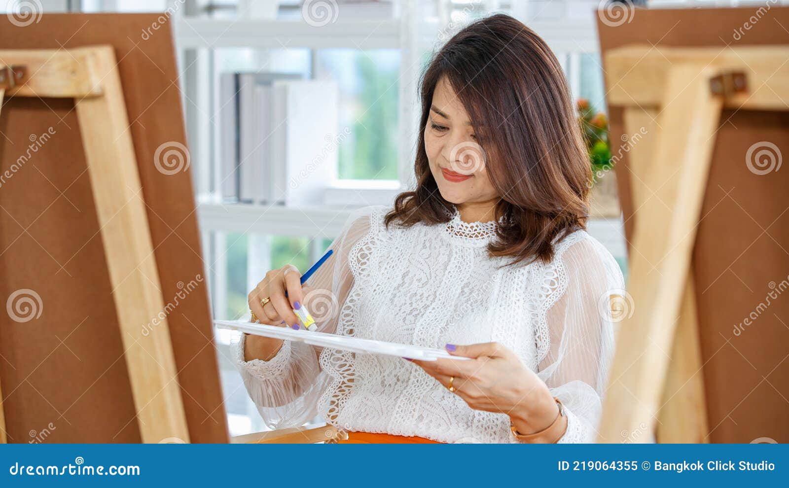 senior woman couple in casual dress painting image in the home gallery with warm and happy circumstance. idea for hobby and art