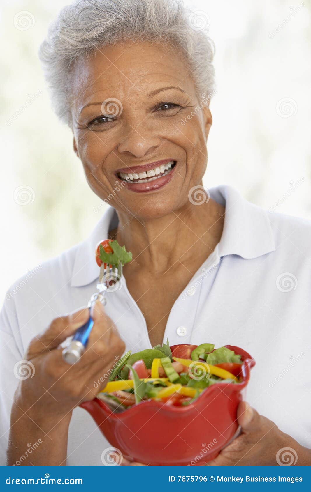 senior woman eating a fresh green salad