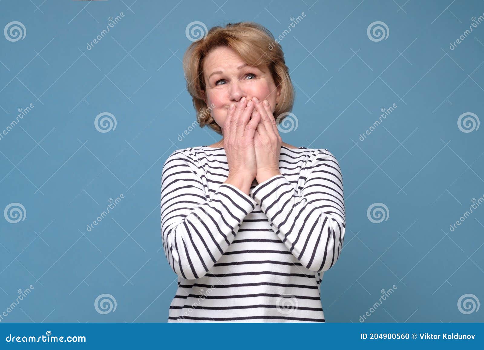 senior woman giggle covering mouth with hands. gossip concept.