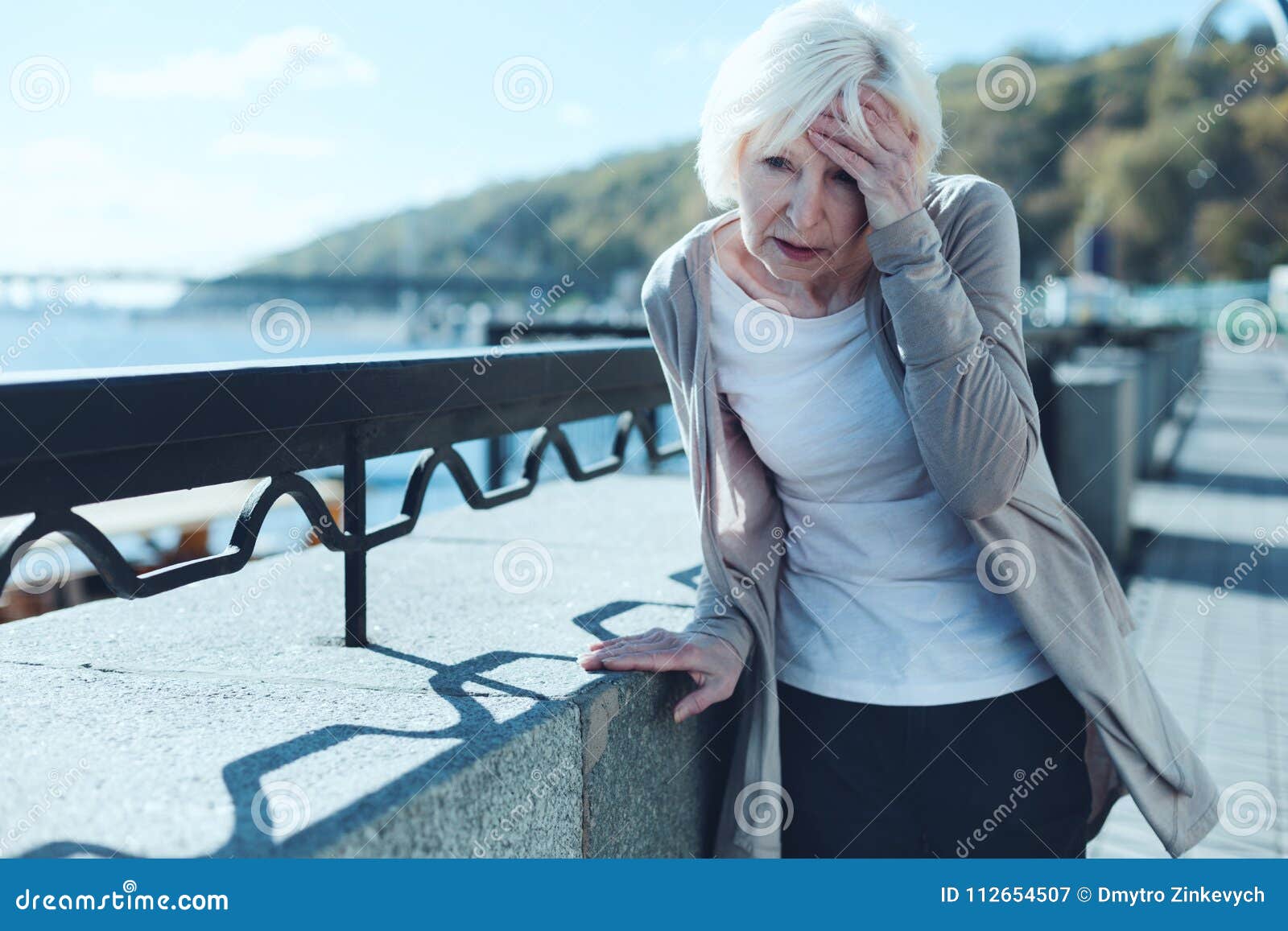 senior woman having vertigo outdoors