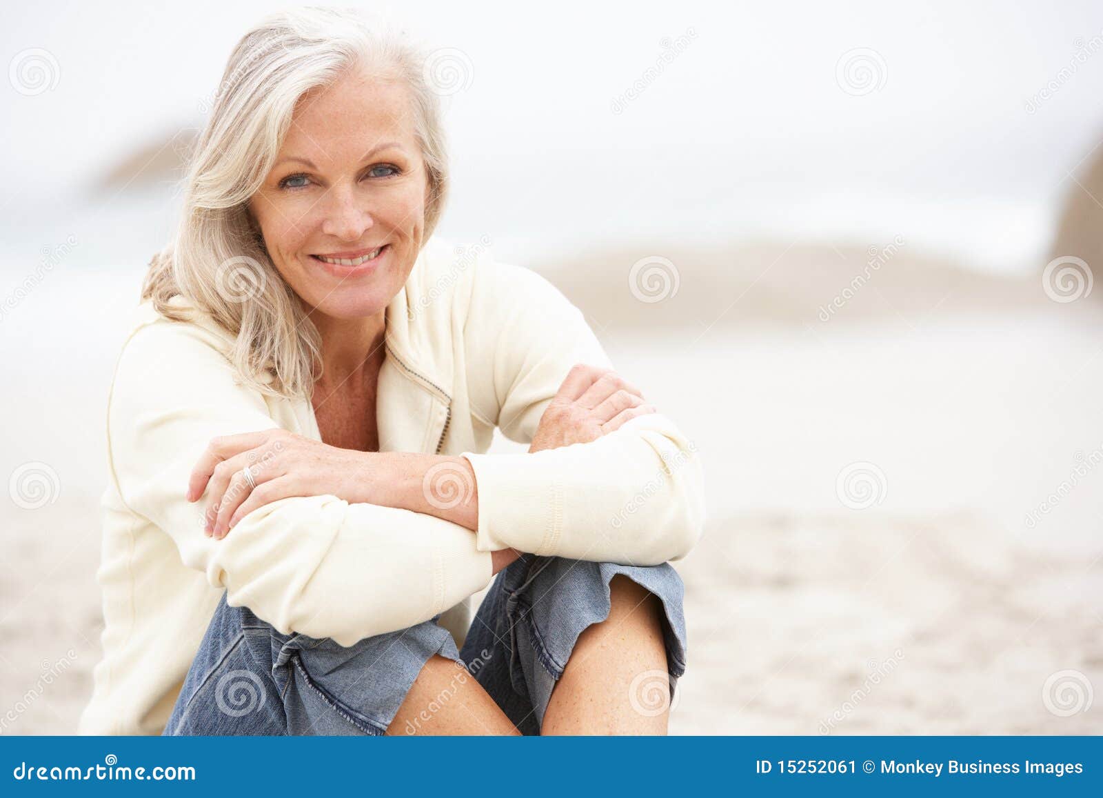 senior woman on holiday sitting on winter beach