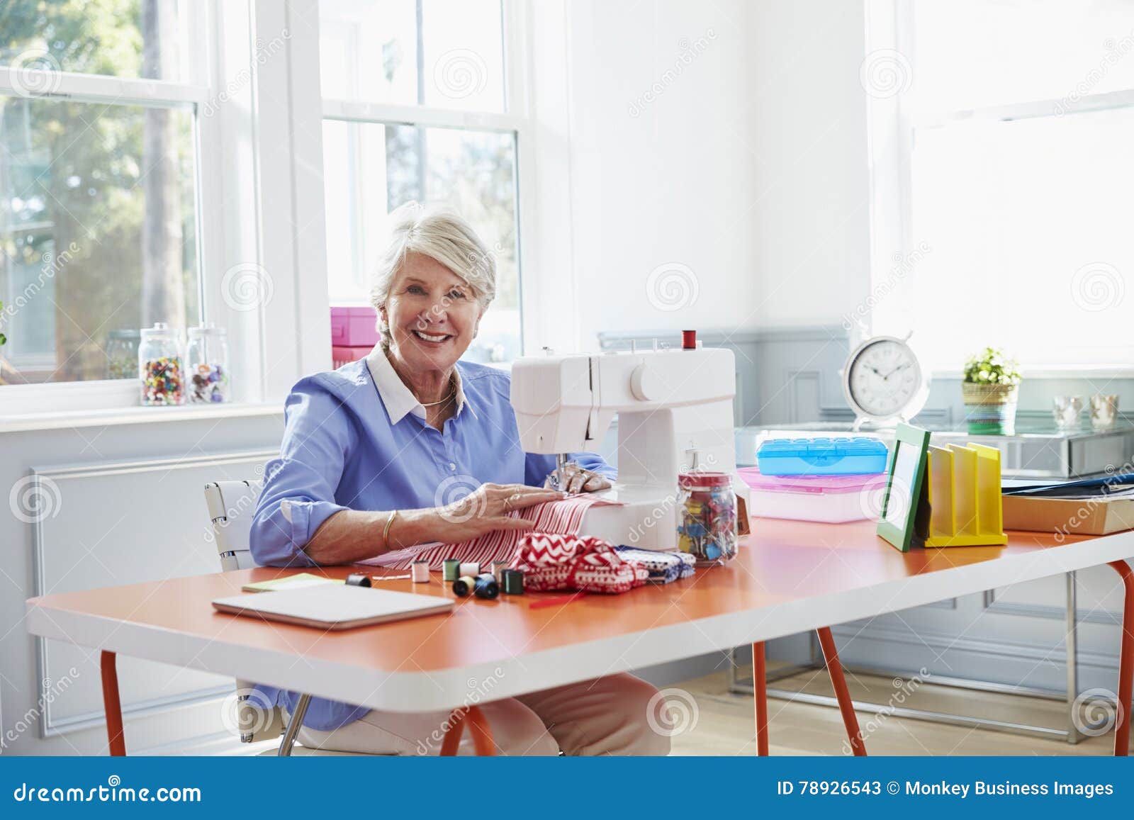Senior Woman Making Clothes Using Sewing Machine at Home Stock Image