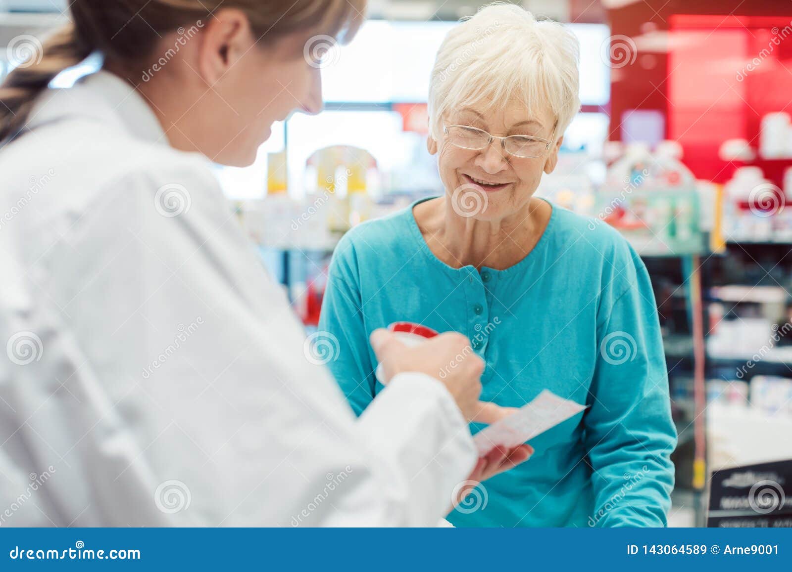 senior woman in pharmacy talking to the chemist or pharmacist