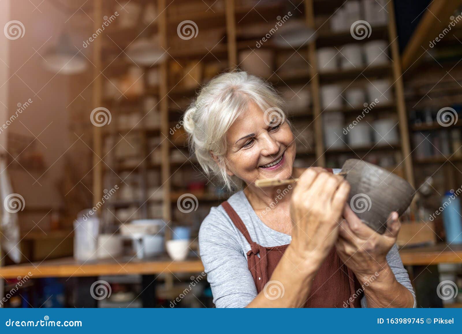 senior woman pottery artist makes ceramics from clay