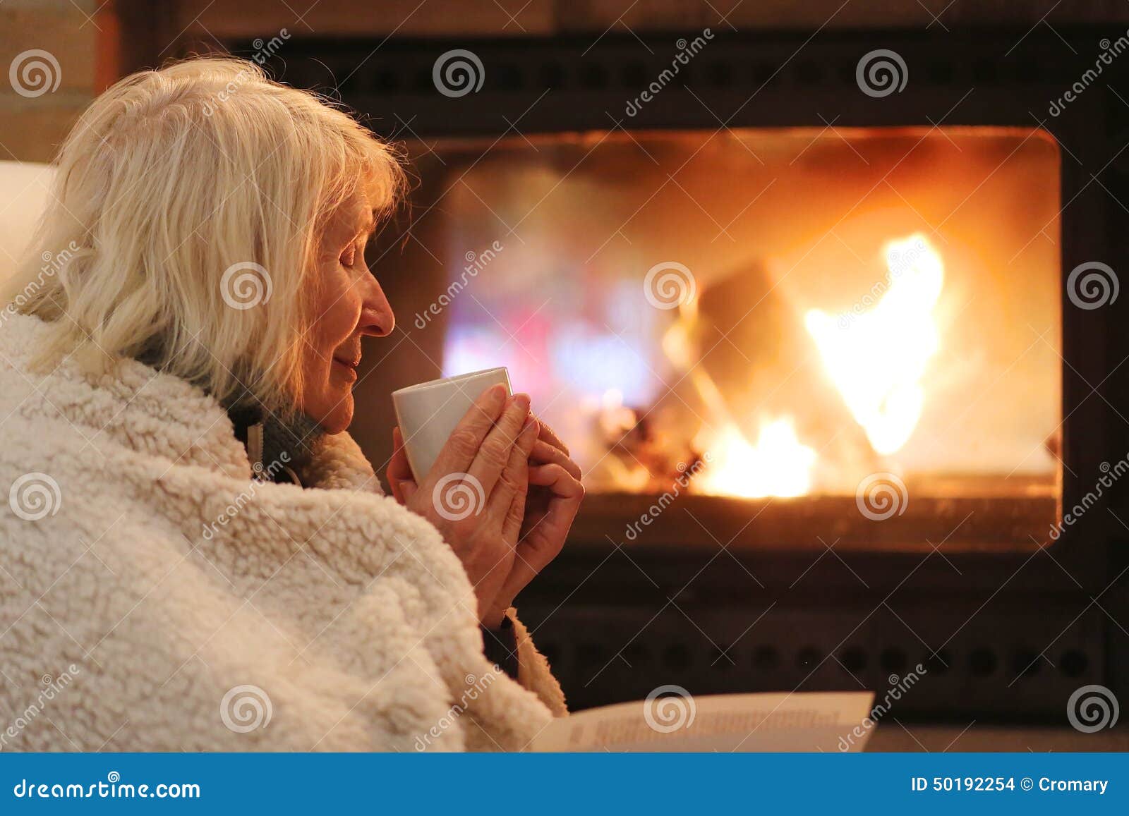 senior woman relaxing by fireplace