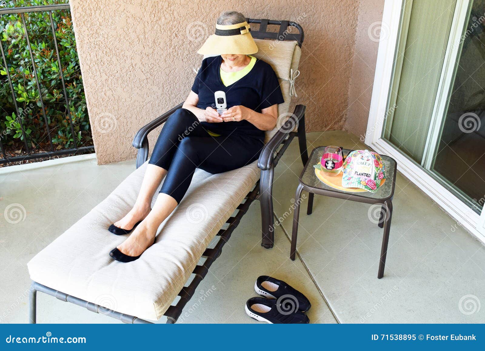 senior woman relaxing and texting in her patio in laguna woods california.