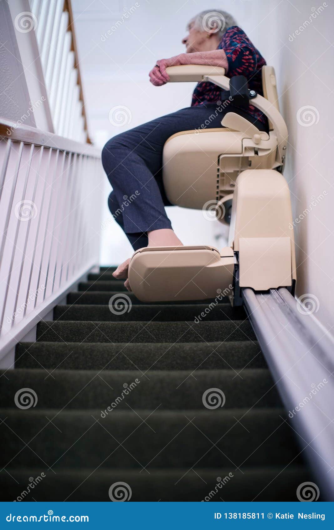 senior woman sitting on stair lift at home to help mobility