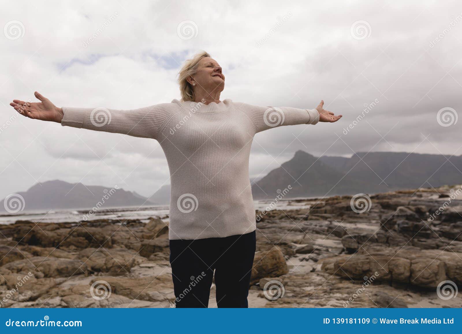 Senior Woman Standing With Arms Outstretched At The Beach Stock Image Image Of Looking