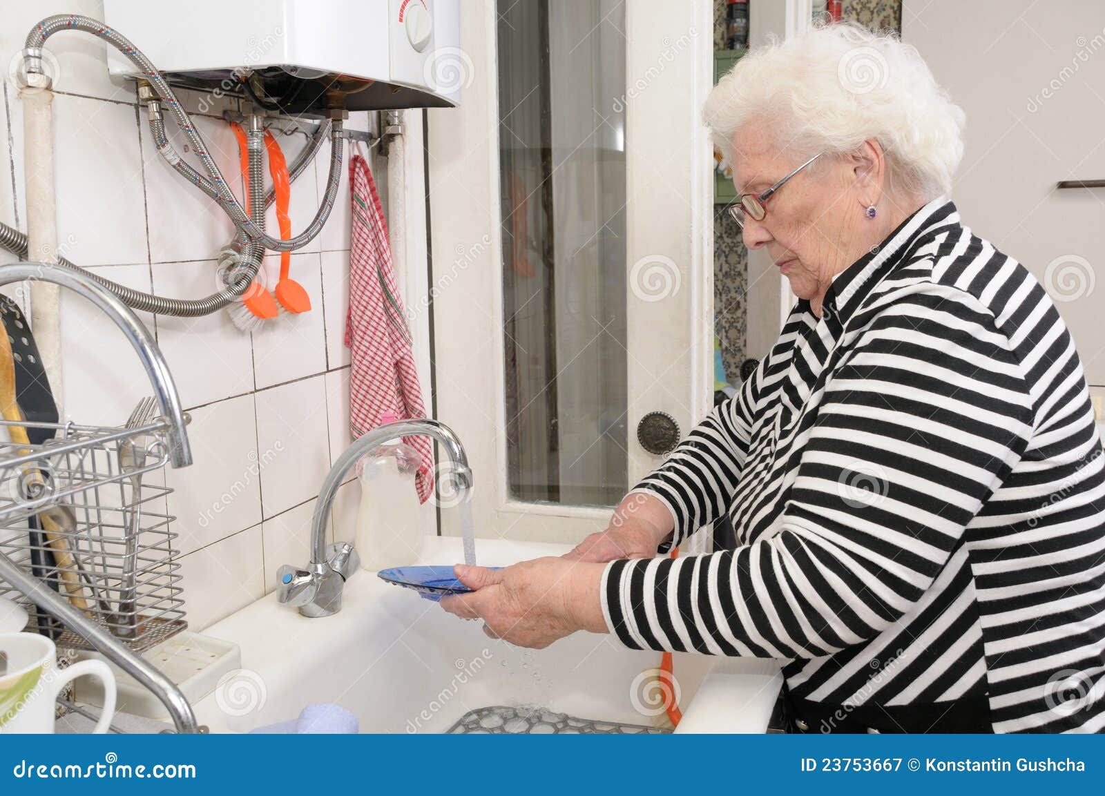 Senior woman washes dishes stock image. Image of home 23753667