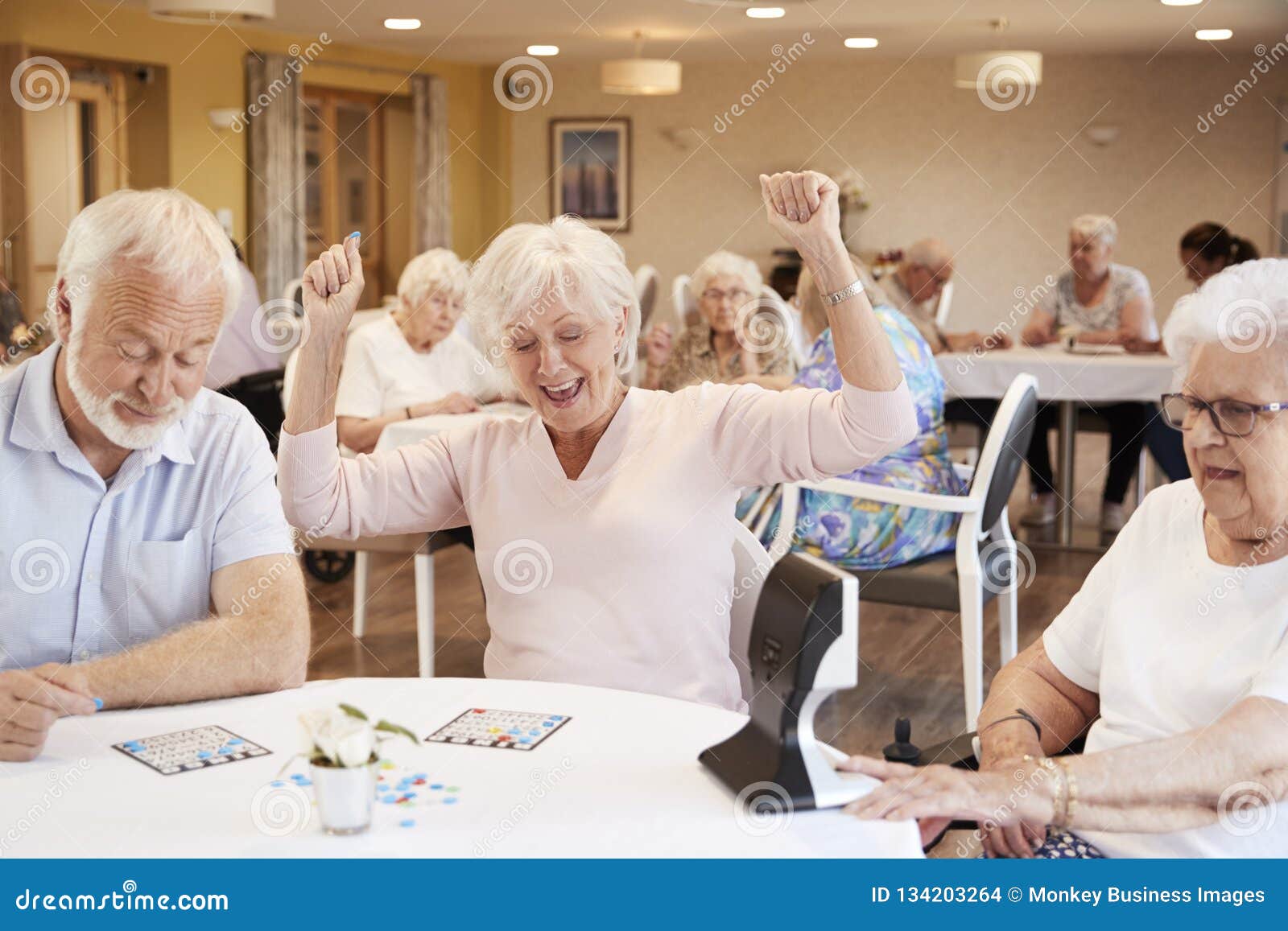 senior woman winning game of bingo in retirement home