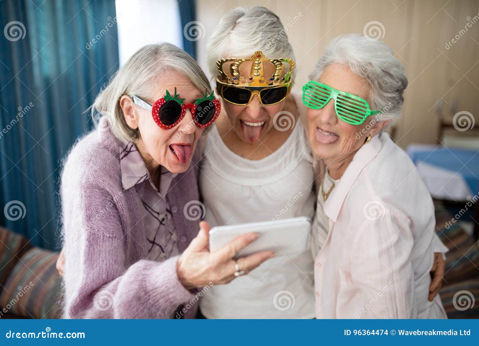 senior women wearing novelty glasses making face while taking selfie
