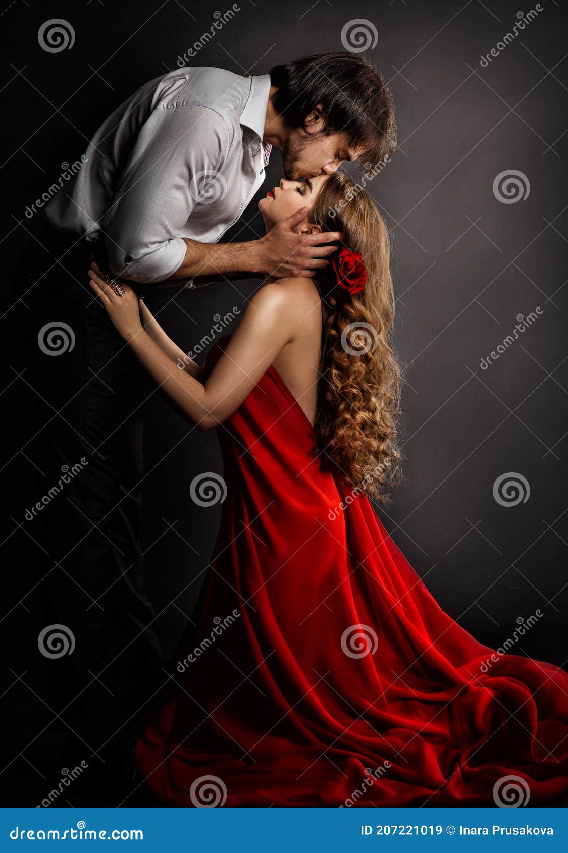 sensual couple kissing in love. handsome man hugging romantic woman in red dress. valentines people concept