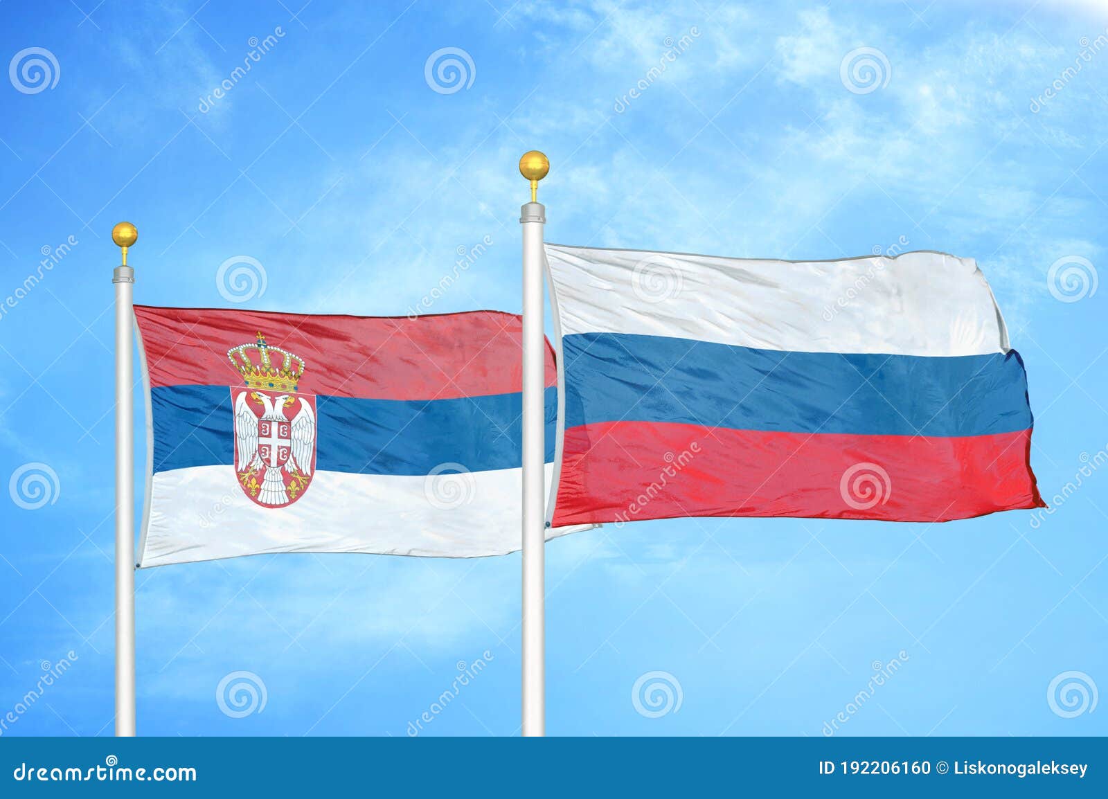 serbia and russia two flags on flagpoles and blue sky