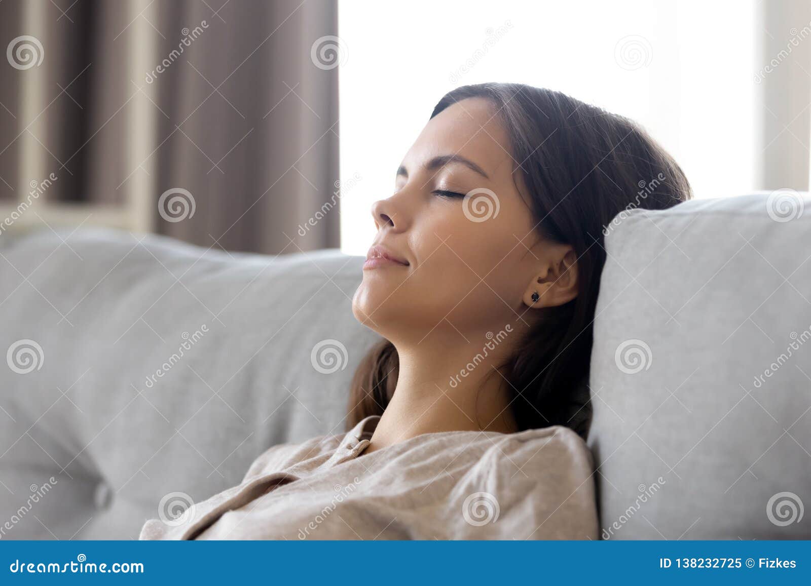 serene calm woman relaxing leaning on comfortable couch having nap