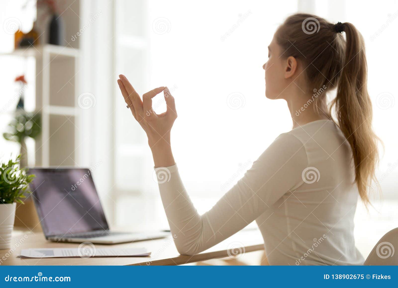 Serene Healthy Calm Woman Sitting At Desk Doing Yoga Exercises