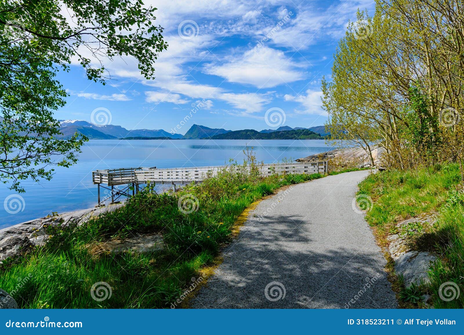 serene morning stroll along idyllic seaside path amidst majestic mountains