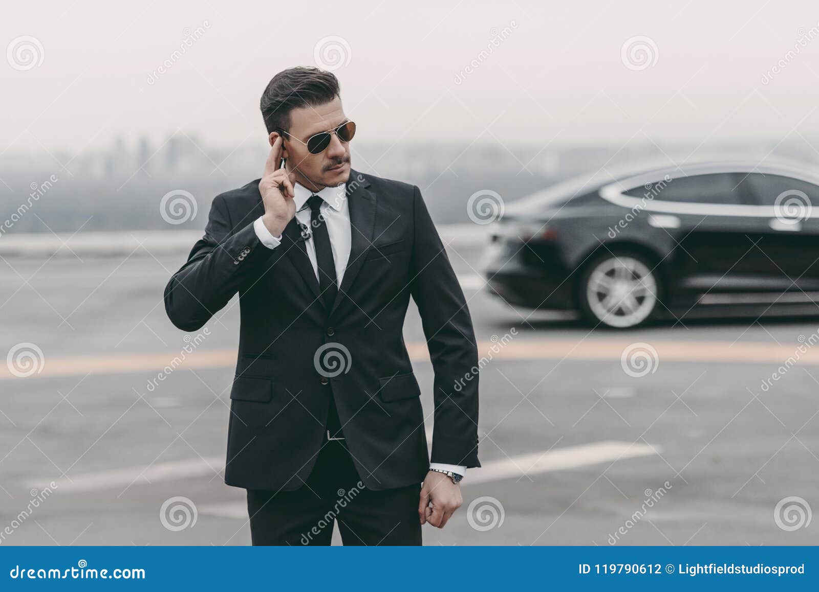 serious bodyguard listening message with security earpiece