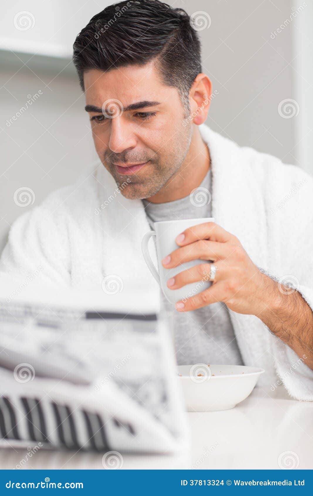 serious casual man with coffee cup reading newspaper