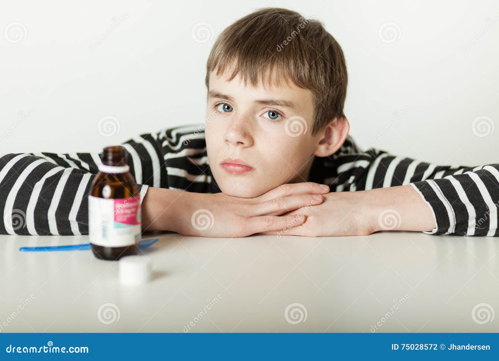 Serious Child With Chin On Arms Near Medicine Stock Photo ...
