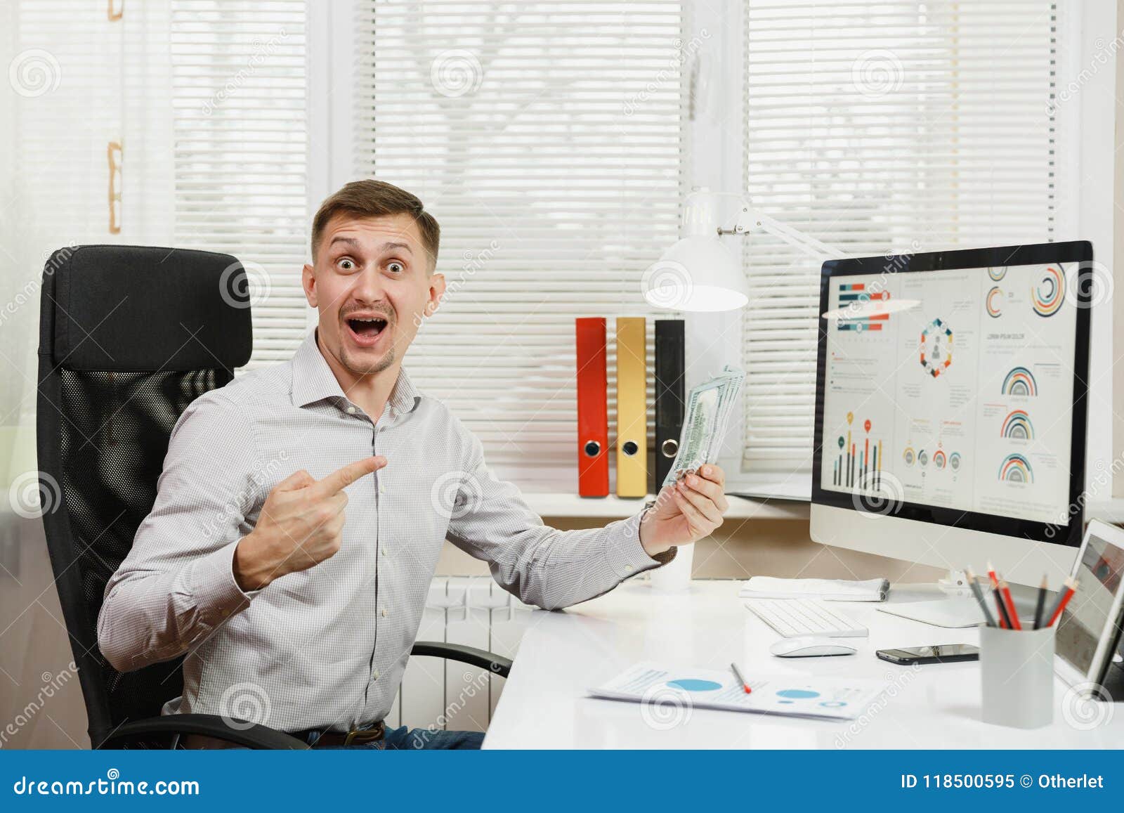serious and engrossed business man in shirt sitting at the desk, working at computer with modern monitor. manager or worker.