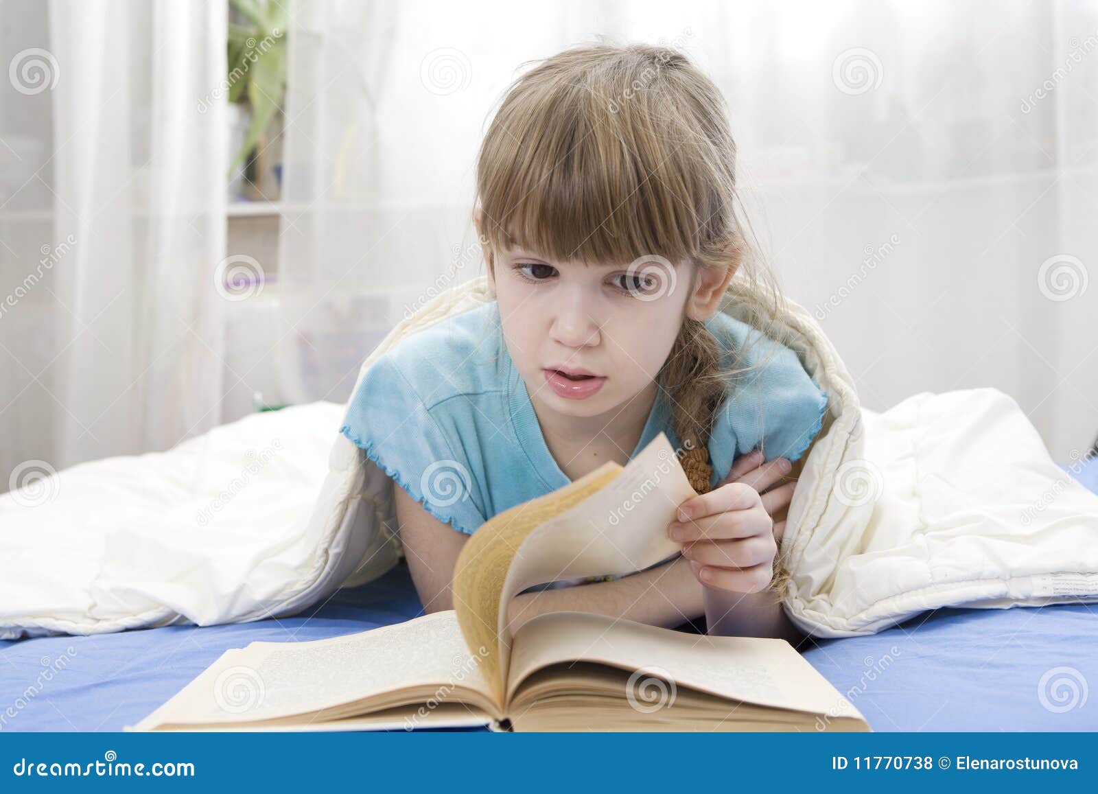 Serious Girl Reading a Book Lying in Bed Stock Photo Image of child