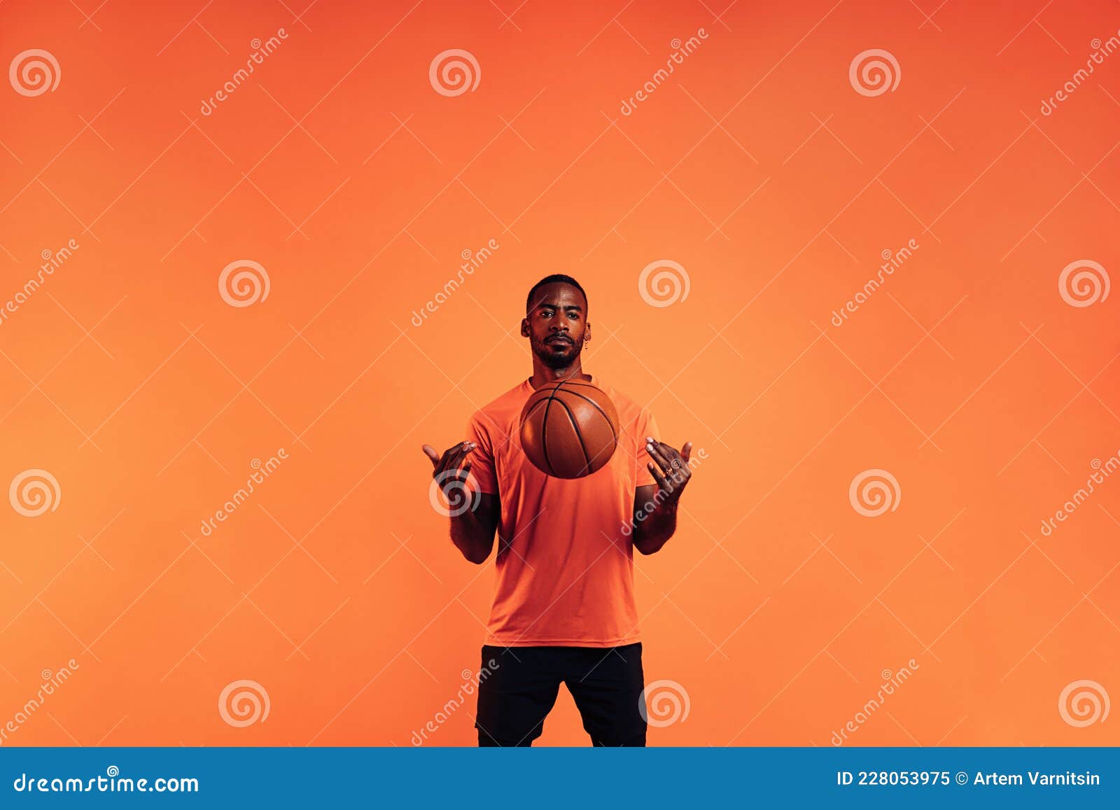 Serious Guy in Sportswear Throws a Basketball in Front of Him in the