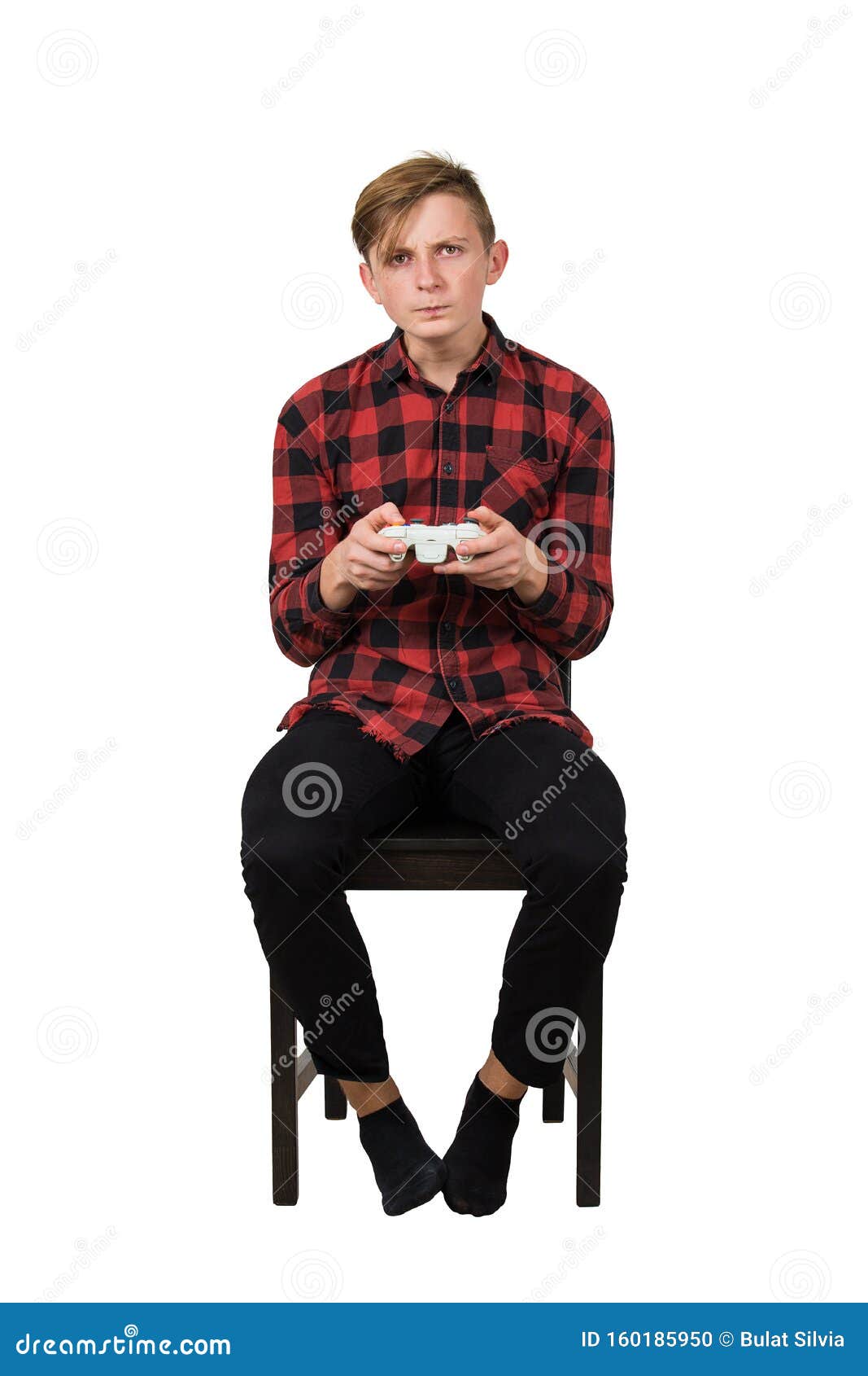 serious intent teen guy seated on chair playing video games  over white background. boy stand all ears holding joystick