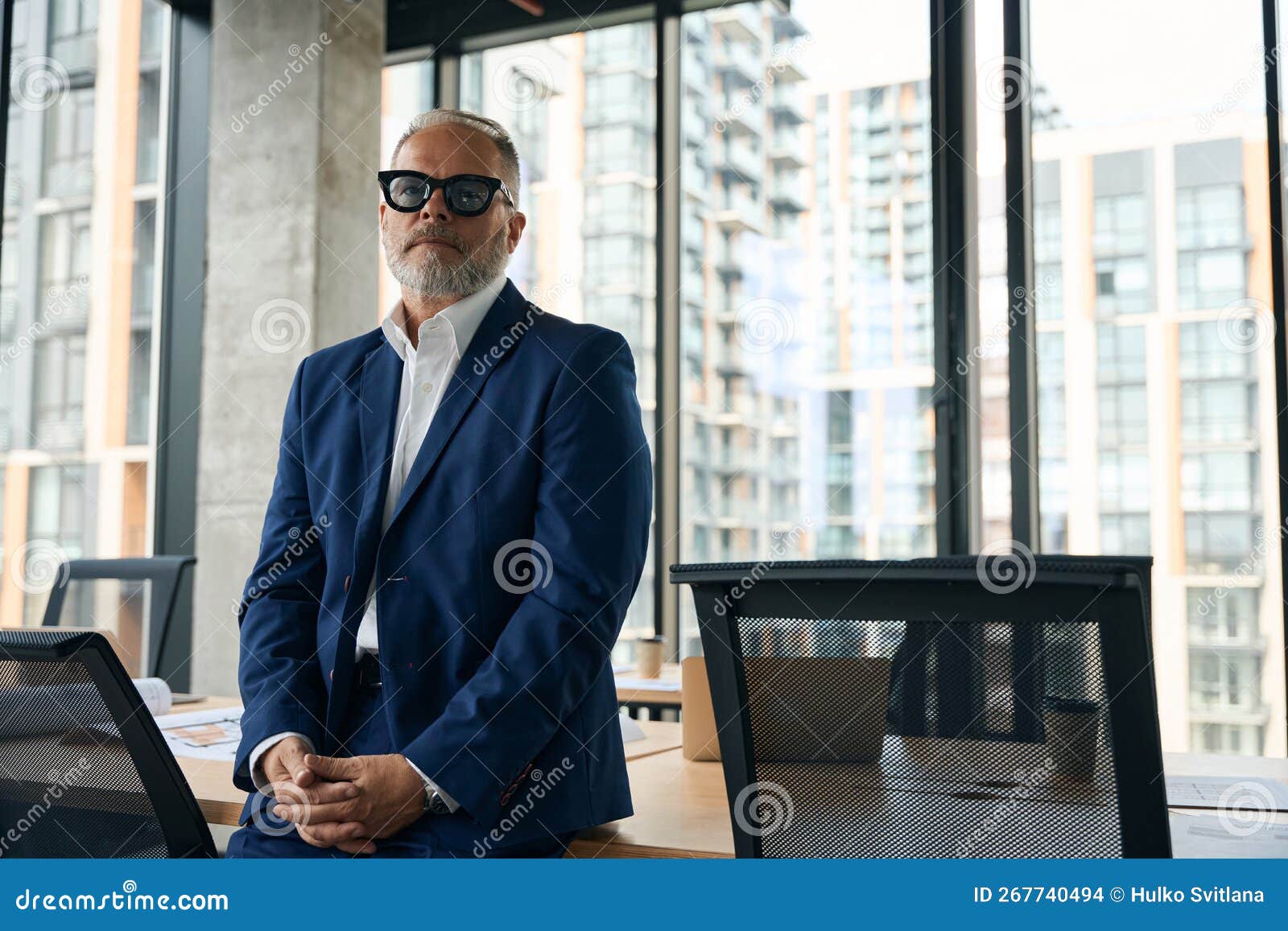 Seriouslooking Office Worker Posing in His Workspace Stock Photo