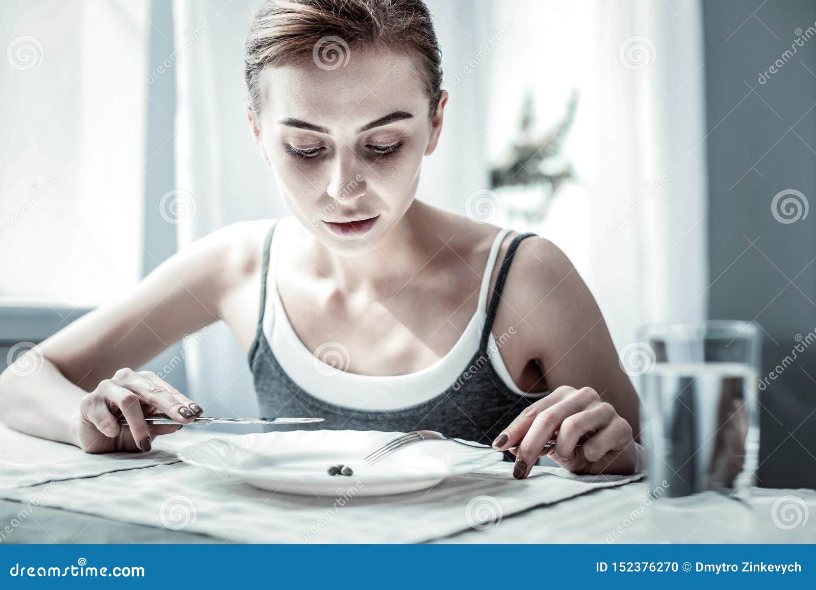 attentive young female person staring at her plate