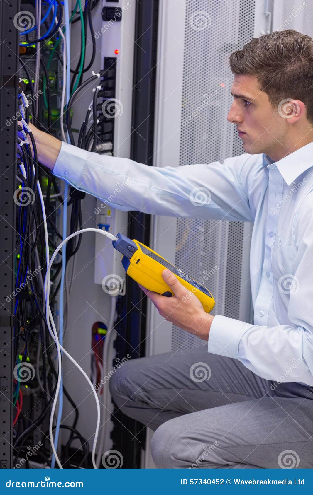 Serious Technician Using Digital Cable Analyzer on Server Stock Photo