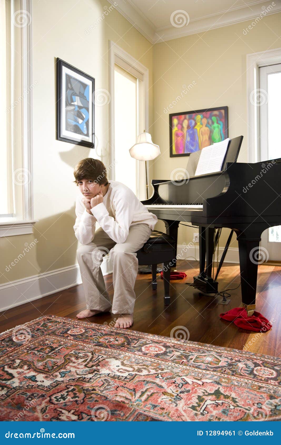 Serious Teenage Boy Sitting On Piano Bench Stock Image 