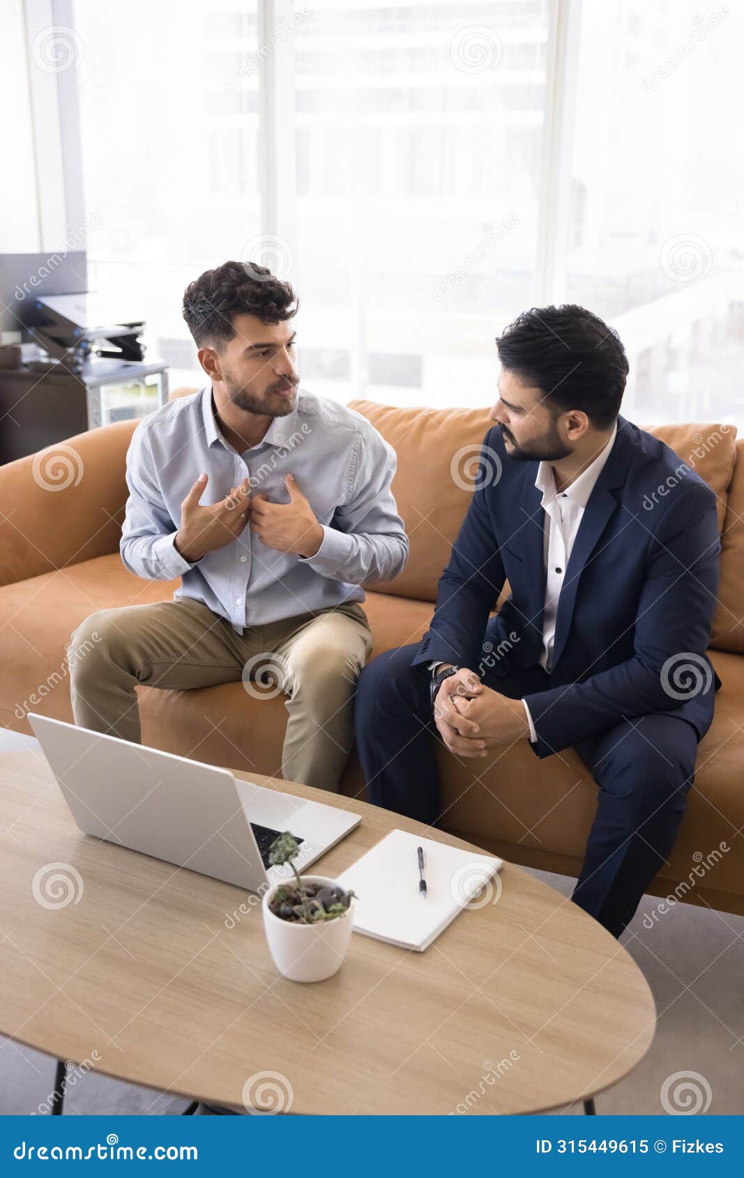 serious young arab employee man talking to indian colleague