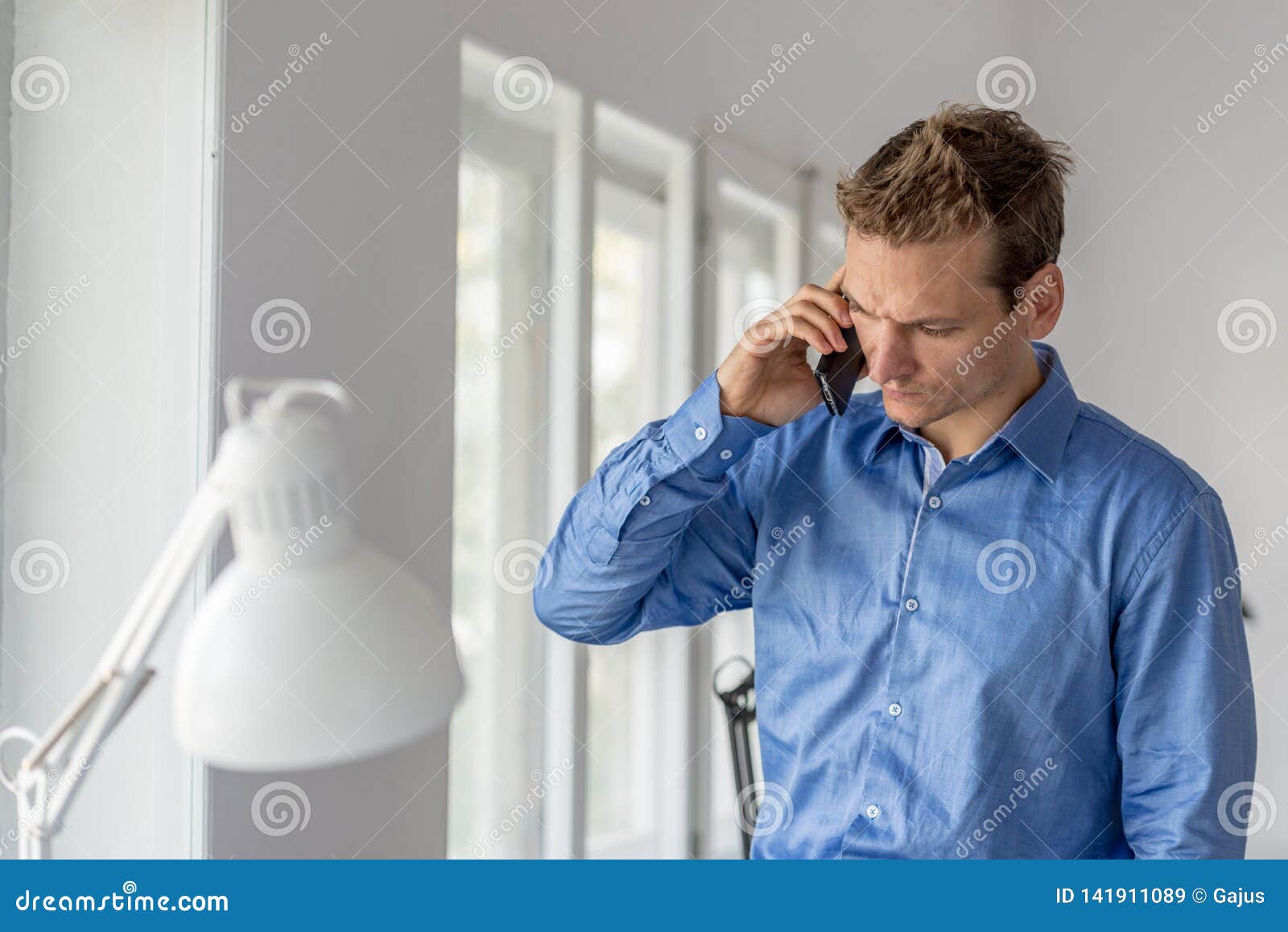 Serious Young Businessman Engaged in an Important Conversation Using His Smart Phone Stock Image