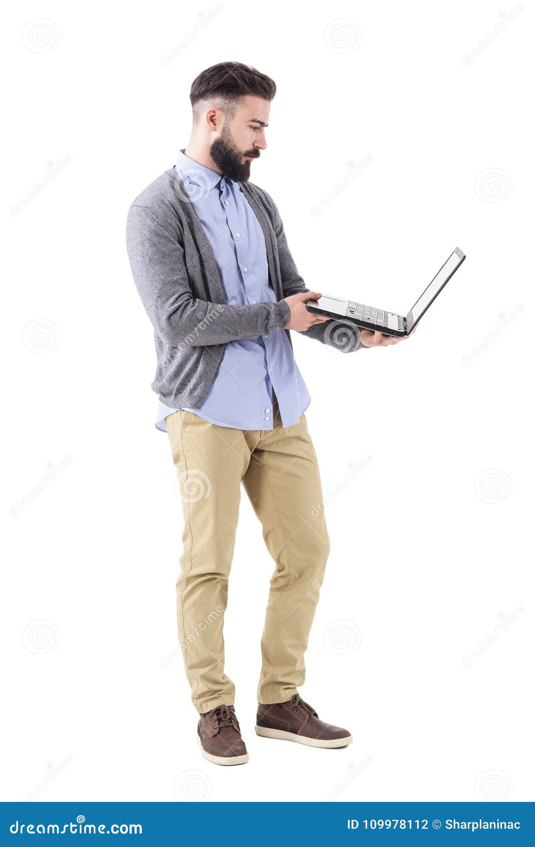 Serious Young Businessman Holding and Looking at Tablet Computer Screen ...