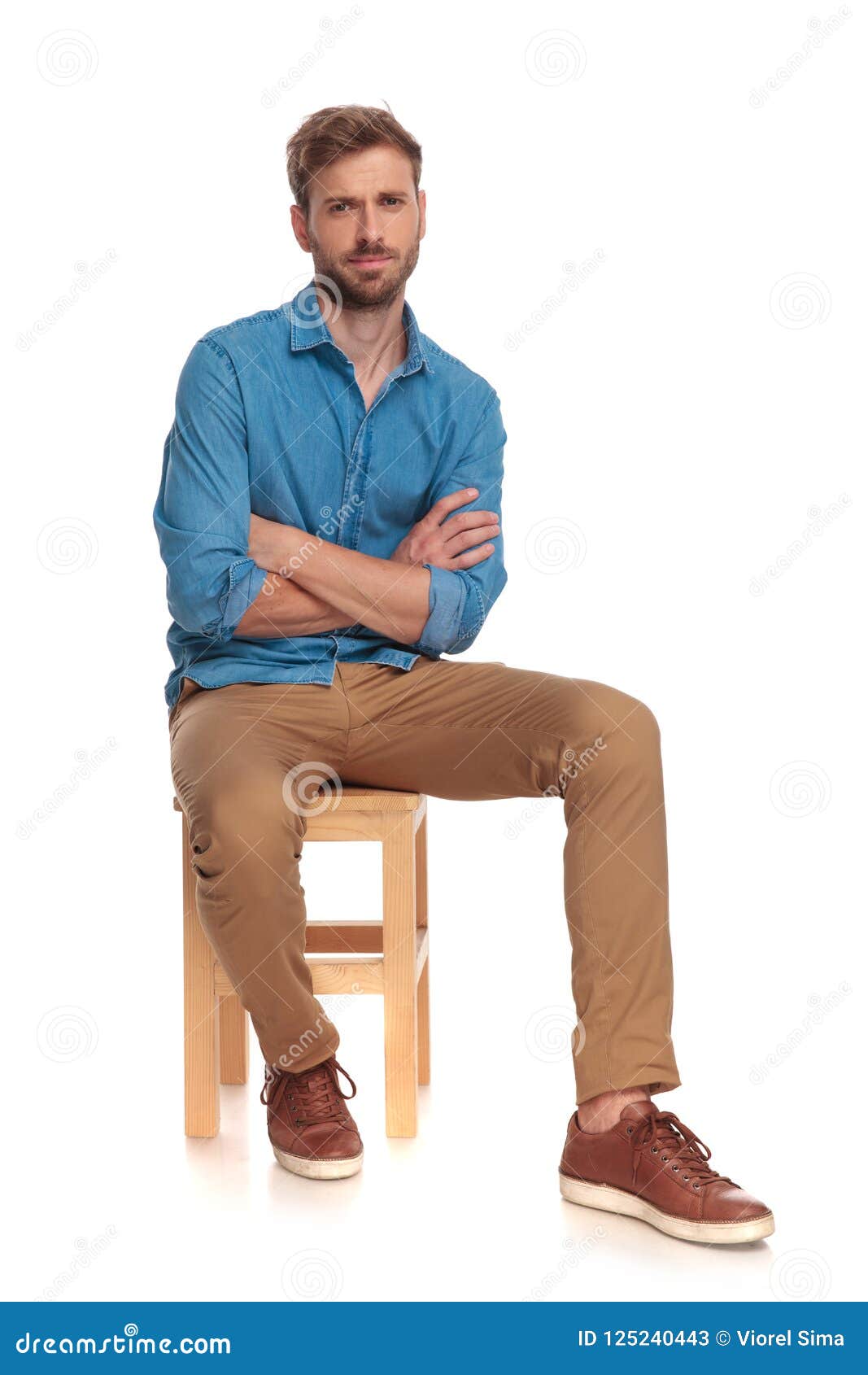 Serious Young Casual Man Sitting With Hands Crossed Stock Image - Image ...