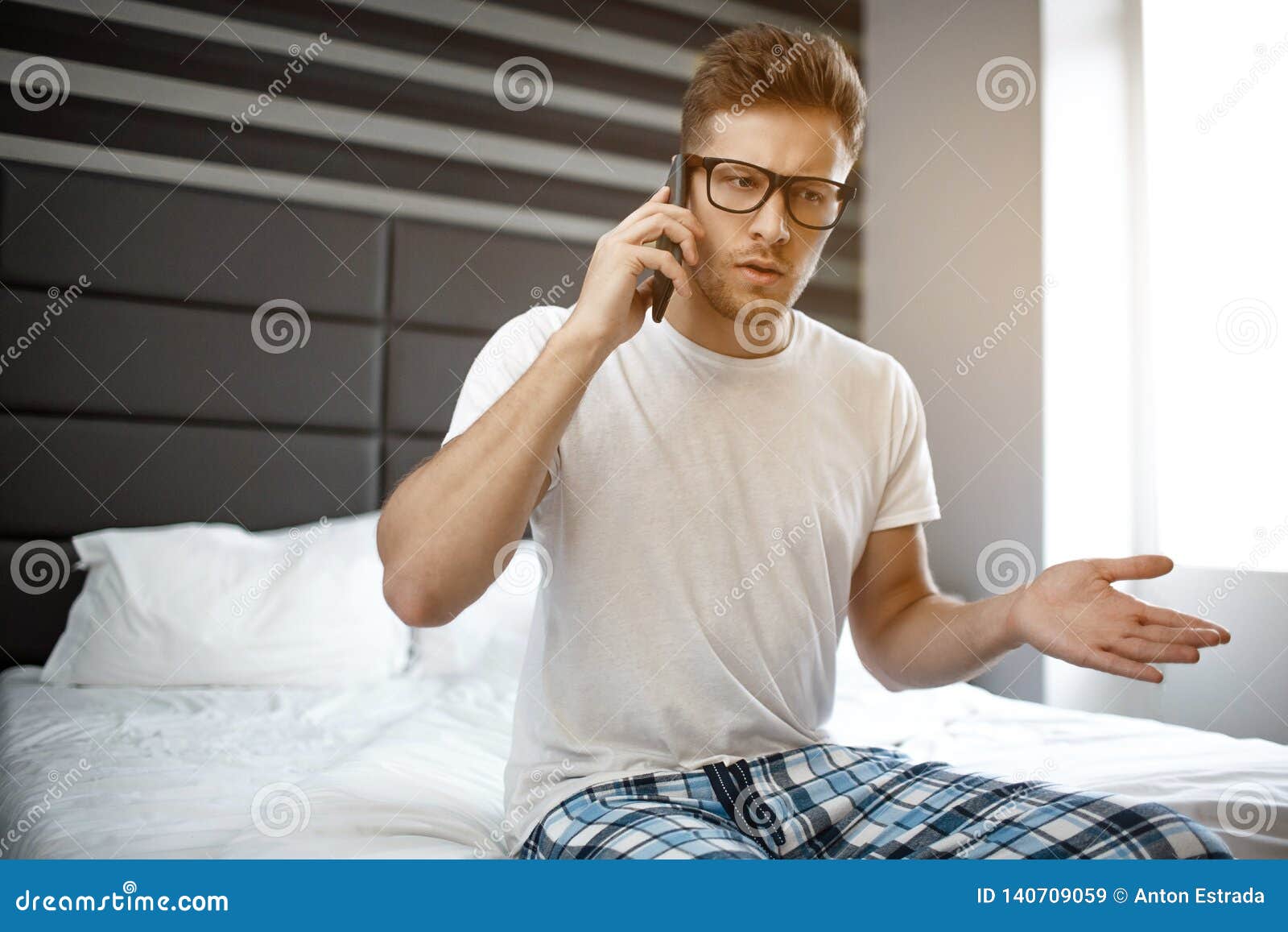 He talked. Парень разговаривает по телефону на кровати. Мужчина в кровати говорит по телефону. Человек на кровати сидит разговаривает по телефону. Парень говорит по телефону в кровати.