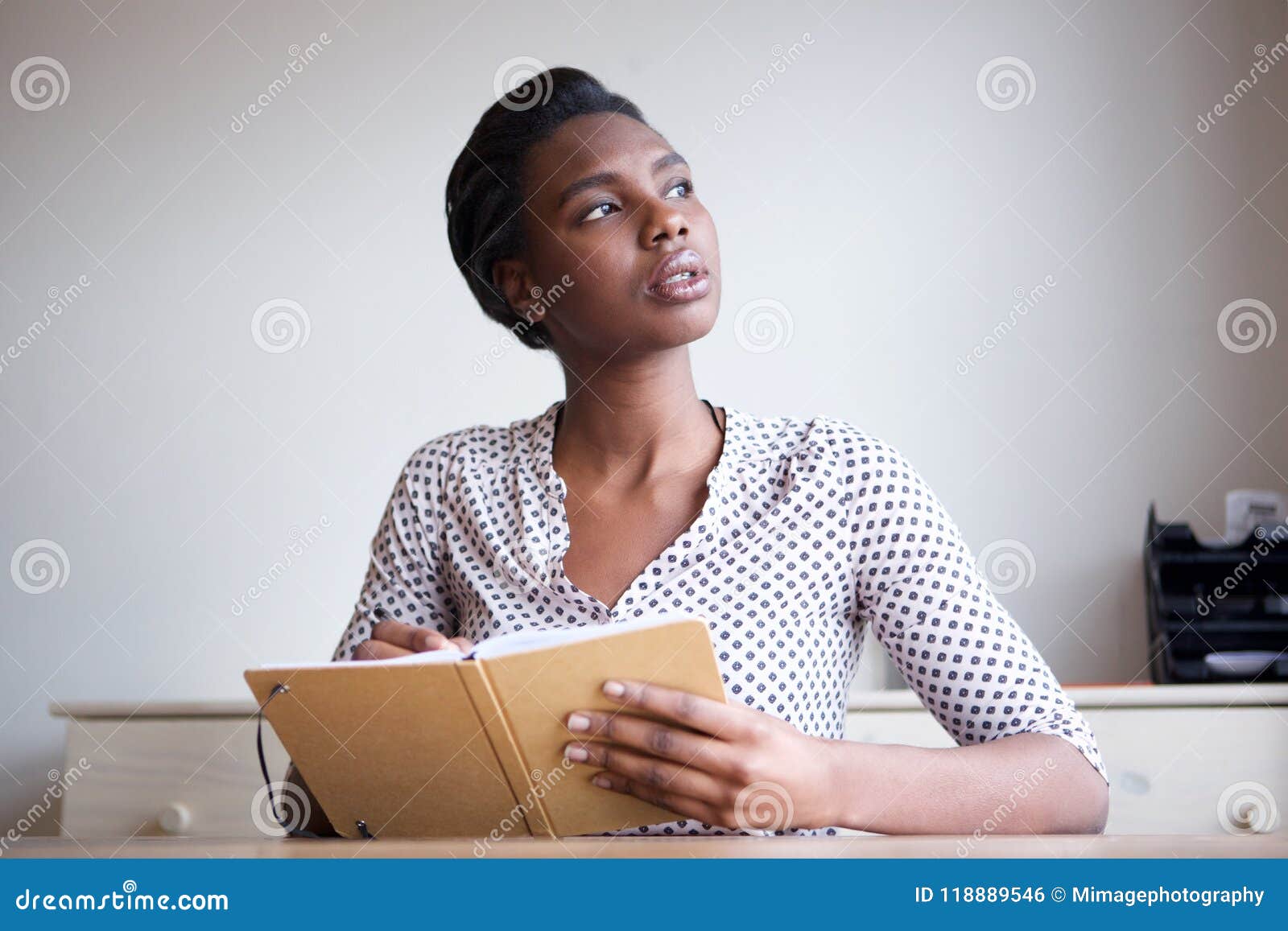 serious young woman thinking and writing in journal