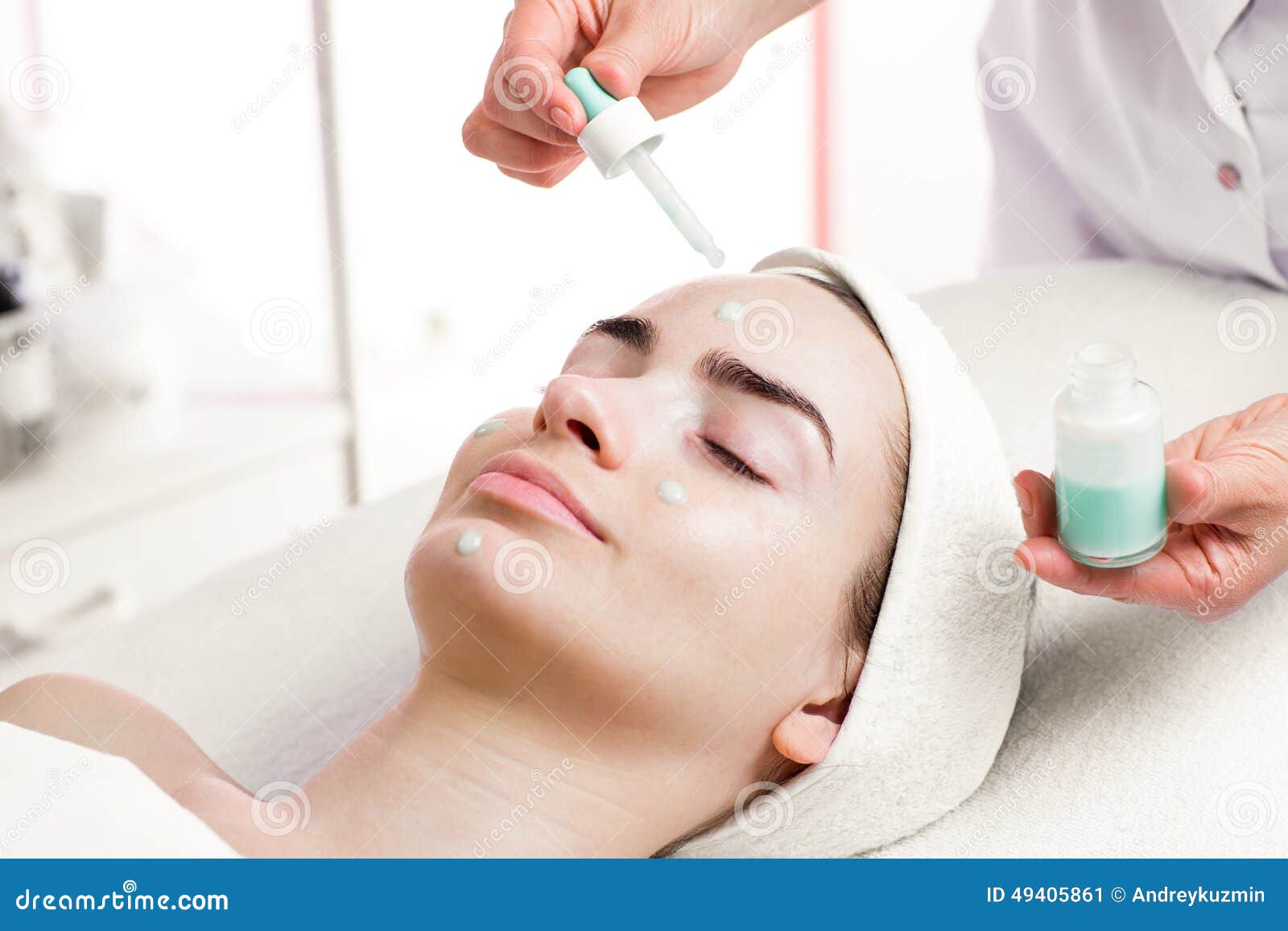 serum facial treatment of young woman in spa salon
