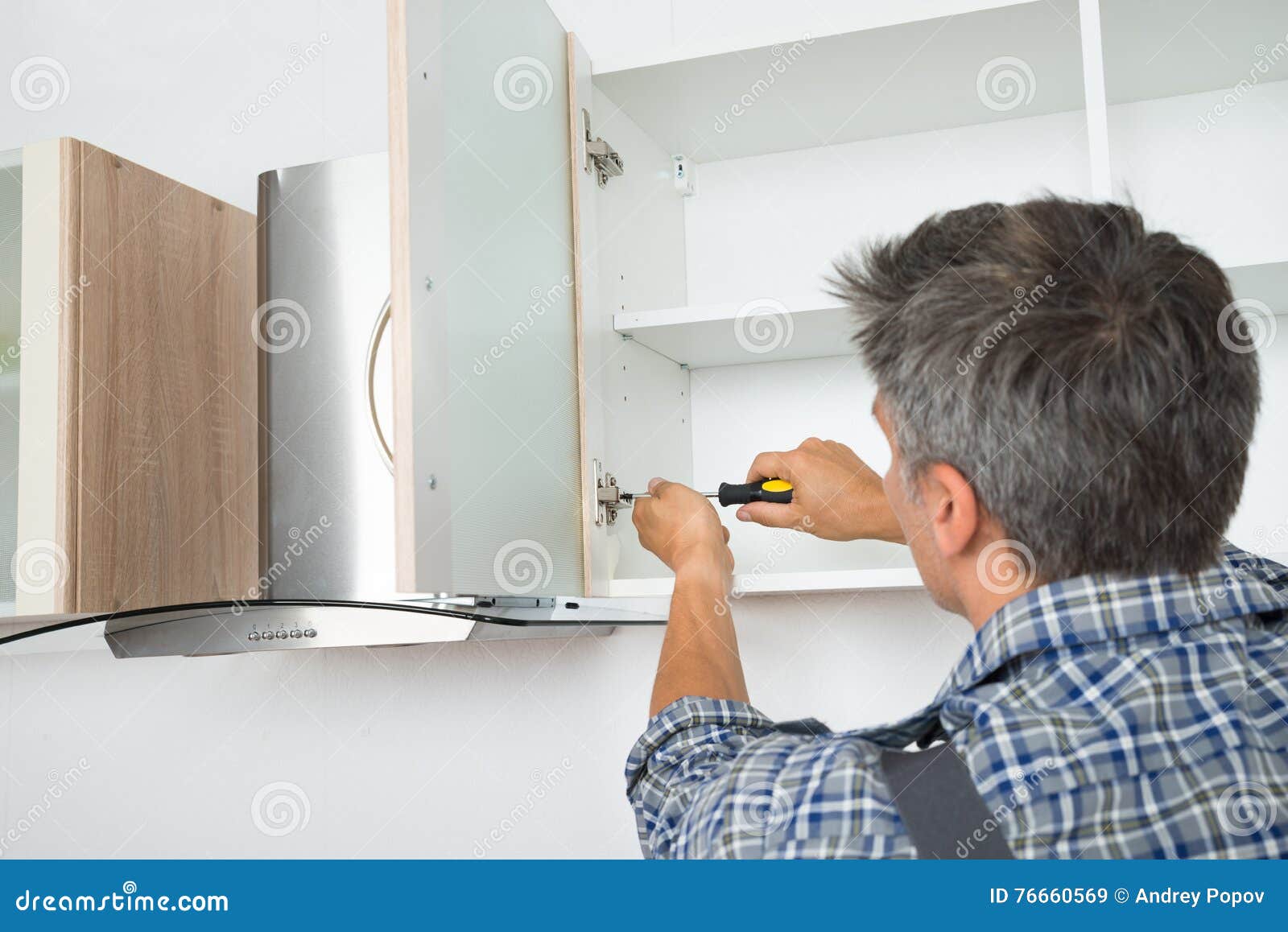 Serviceman Fixing with Screwdriver in Kitchen Stock Image